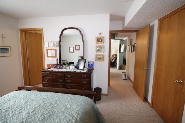 bedroom with light colored carpet and a textured ceiling