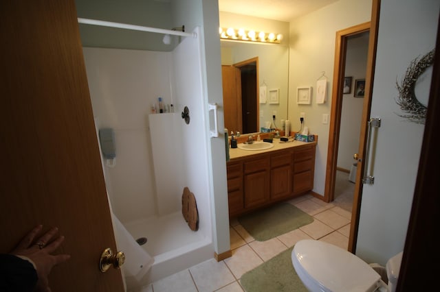 bathroom featuring tile floors, vanity, toilet, and walk in shower