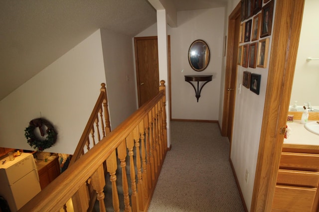 hallway with light colored carpet and vaulted ceiling