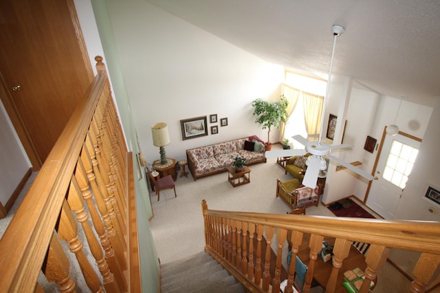 carpeted living room featuring high vaulted ceiling and a textured ceiling