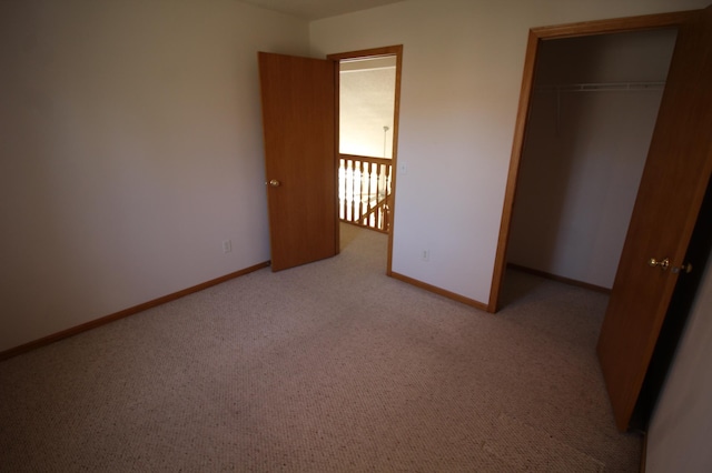 unfurnished bedroom featuring light colored carpet and a closet