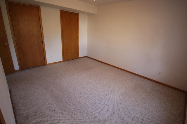 unfurnished bedroom featuring light colored carpet and a closet