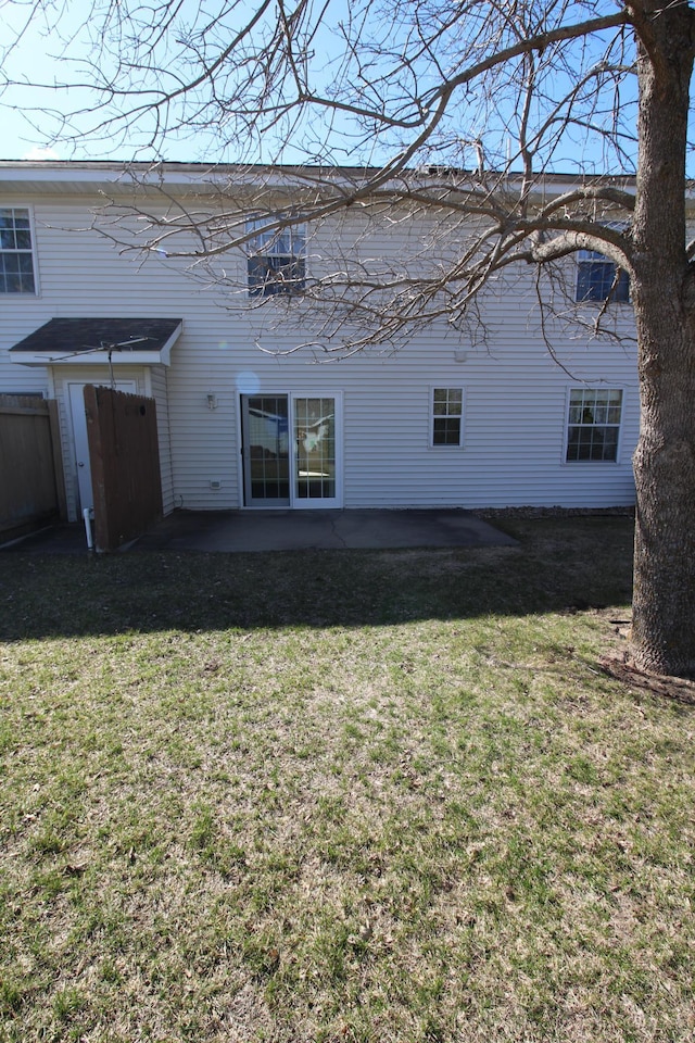 rear view of house with a patio and a lawn