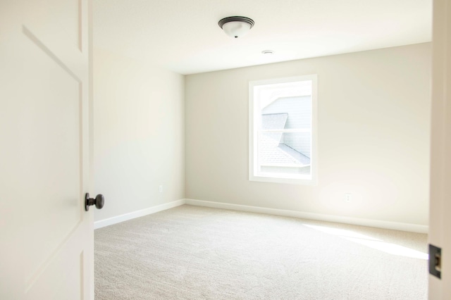 unfurnished room featuring light carpet