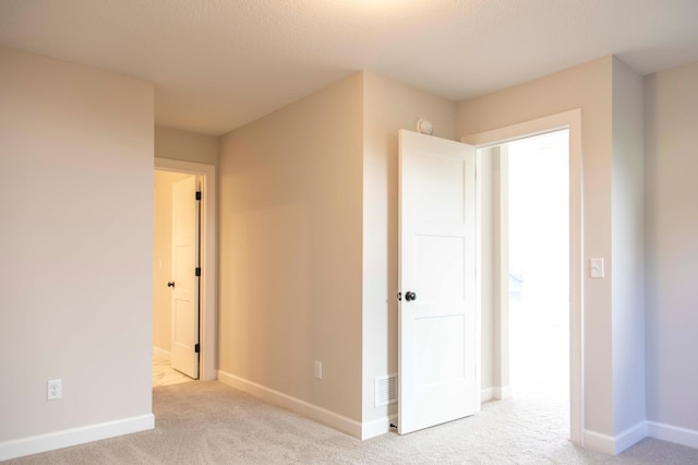 interior space featuring light carpet and a textured ceiling