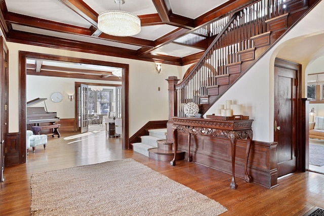 foyer featuring hardwood / wood-style flooring, beam ceiling, a notable chandelier, and coffered ceiling