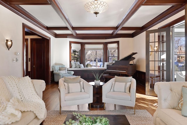 living room featuring a notable chandelier, beamed ceiling, coffered ceiling, and hardwood / wood-style floors