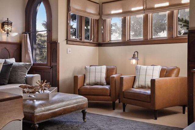 sitting room featuring carpet floors and wooden walls