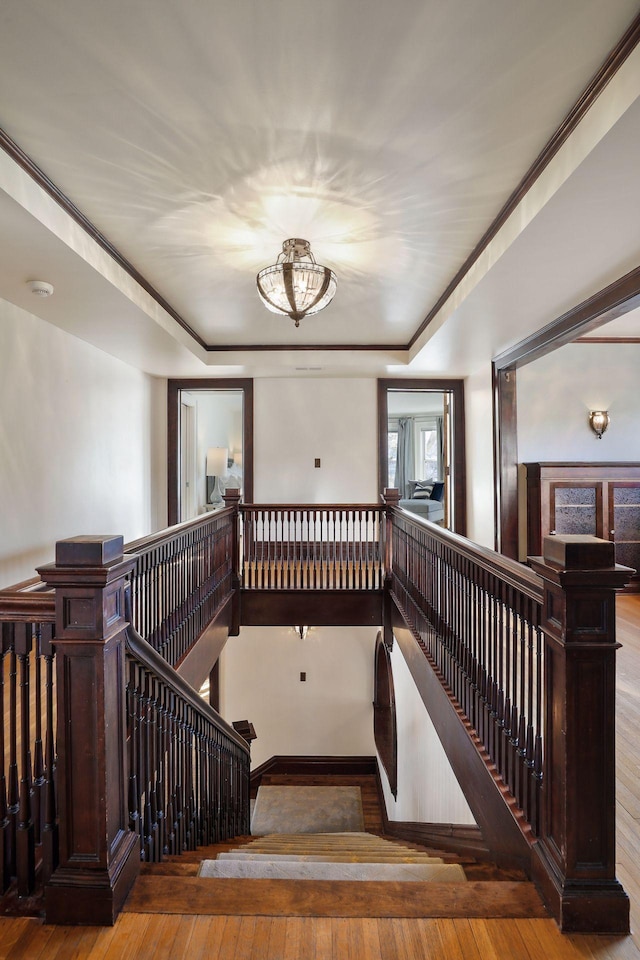 staircase with hardwood / wood-style flooring and ornamental molding