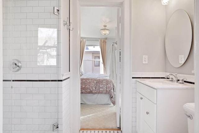 bathroom featuring toilet, vanity, and a tile shower