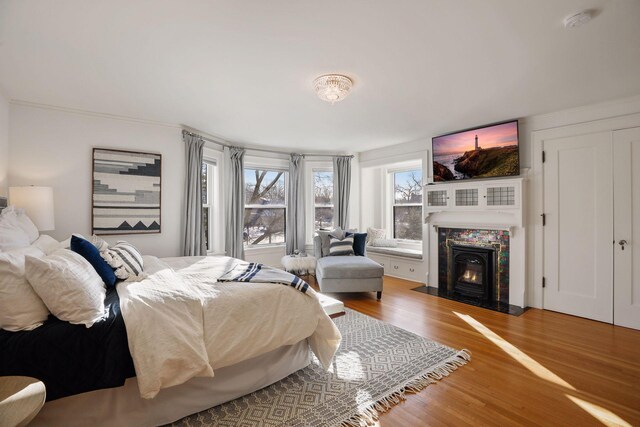 bedroom featuring hardwood / wood-style flooring and a tile fireplace