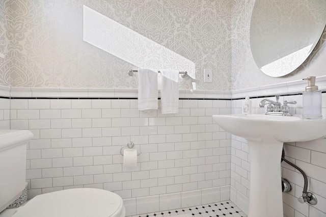 bathroom with toilet, tile walls, and tile patterned flooring