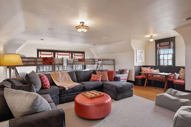 living room featuring lofted ceiling and light wood-type flooring