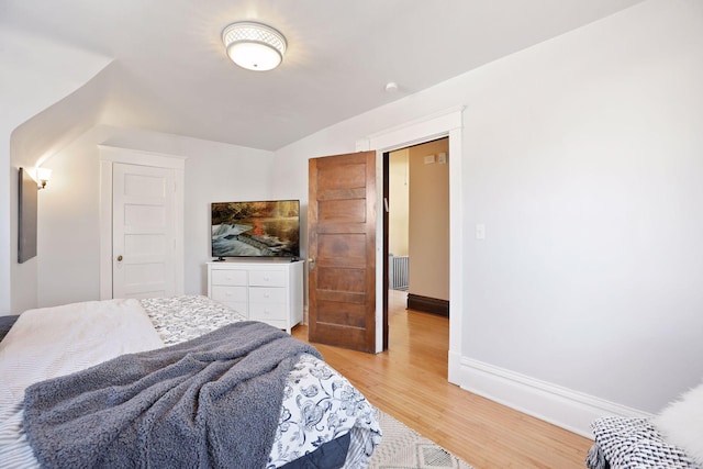 bedroom featuring vaulted ceiling and light hardwood / wood-style floors