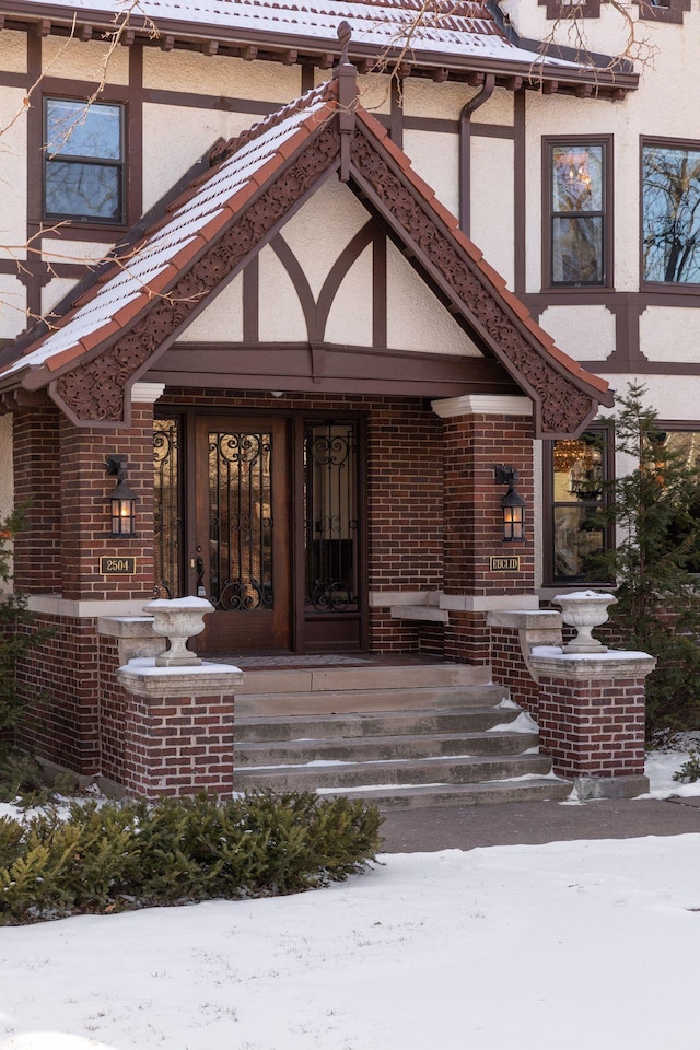 snow covered property entrance with covered porch