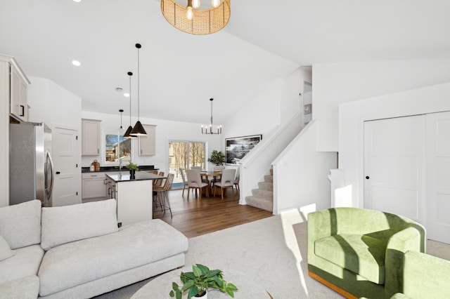 living room featuring high vaulted ceiling, dark hardwood / wood-style floors, and a chandelier