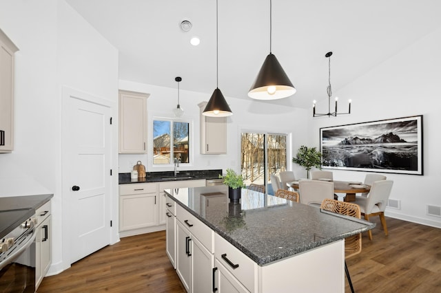 kitchen featuring sink, a center island, dark hardwood / wood-style floors, pendant lighting, and white cabinets