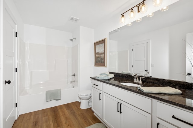 full bathroom featuring vanity, hardwood / wood-style floors, tub / shower combination, and toilet