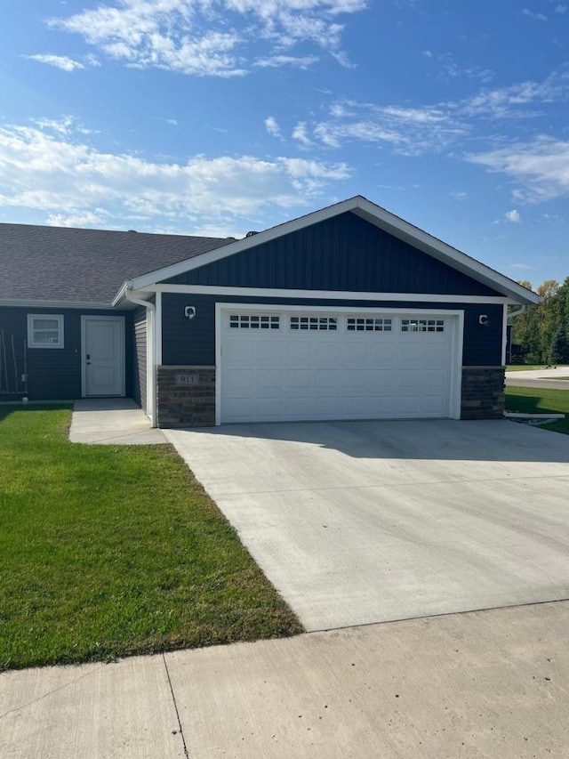 ranch-style house featuring a front lawn and a garage