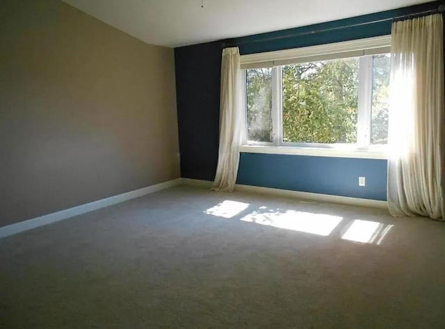 carpeted empty room featuring vaulted ceiling