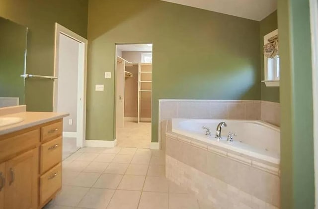 bathroom featuring tile floors, tiled bath, lofted ceiling, and vanity