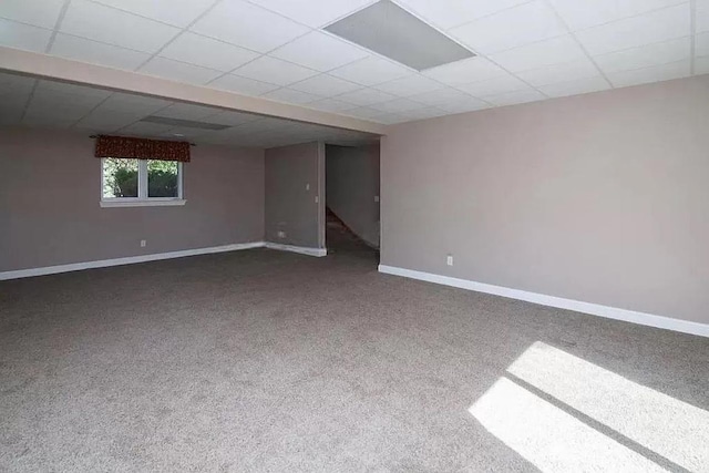 unfurnished room featuring carpet and a drop ceiling