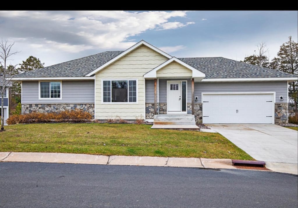 view of front of property featuring a front yard and a garage