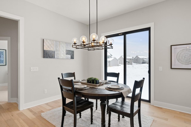 dining room with light hardwood / wood-style floors and an inviting chandelier