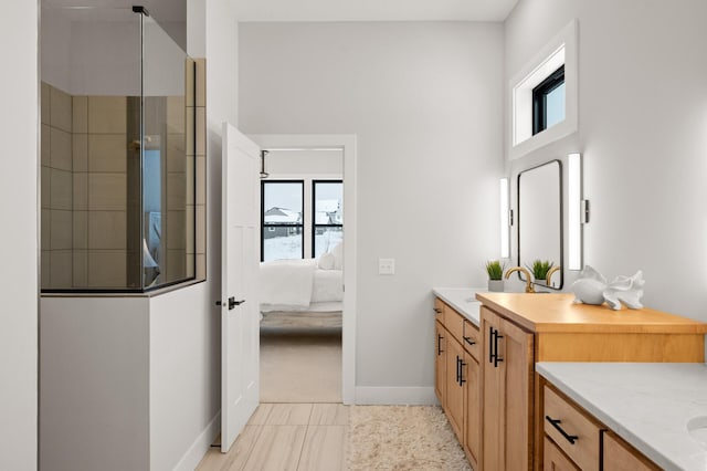 bathroom with tile patterned flooring, a tile shower, and vanity