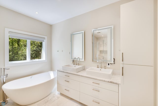 bathroom featuring tile patterned flooring, vanity, and a tub to relax in