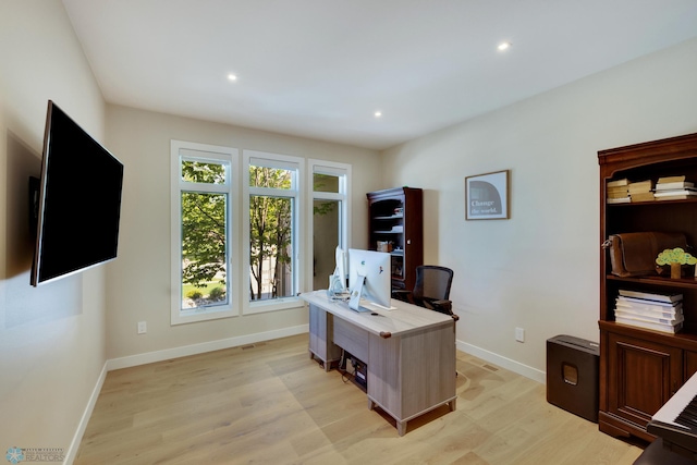 home office with light hardwood / wood-style floors