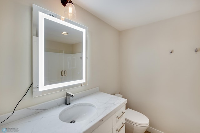 bathroom featuring vanity, toilet, and an enclosed shower