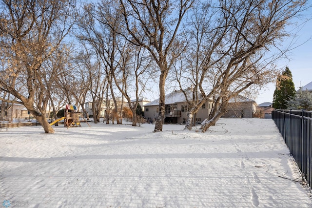 yard layered in snow with a playground