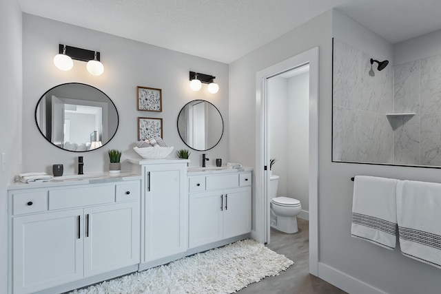 bathroom with vanity, a textured ceiling, and toilet