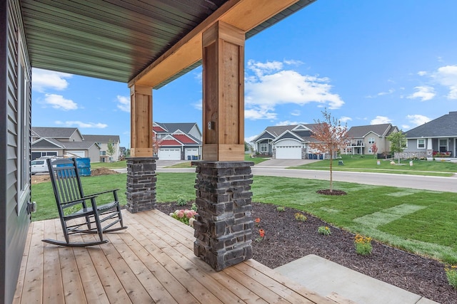 wooden deck featuring a porch and a lawn