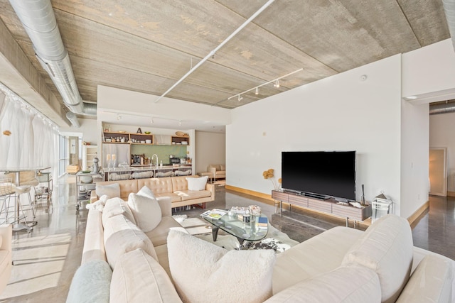 living room with concrete flooring and track lighting