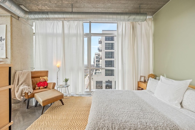 bedroom featuring floor to ceiling windows and concrete floors