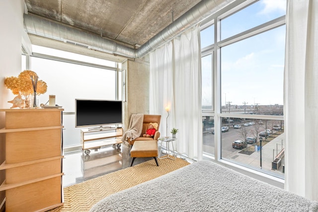 bedroom with a wall of windows and multiple windows