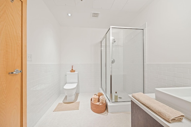 bathroom with tile walls, tile patterned floors, an enclosed shower, and toilet