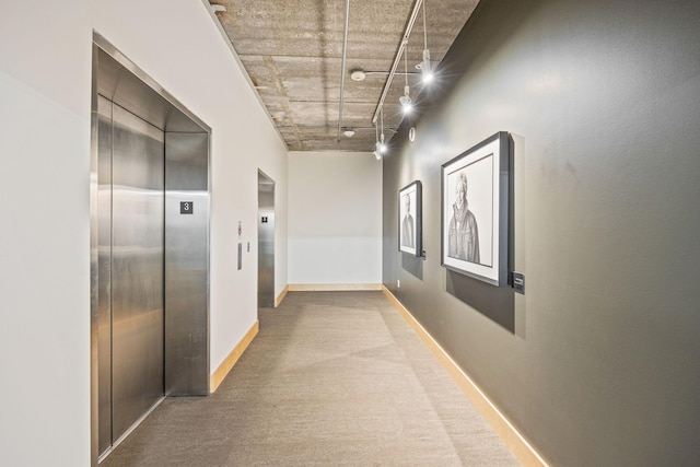 hall with carpet and elevator