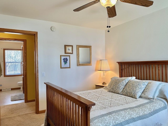 bedroom featuring ensuite bath, light colored carpet, and ceiling fan