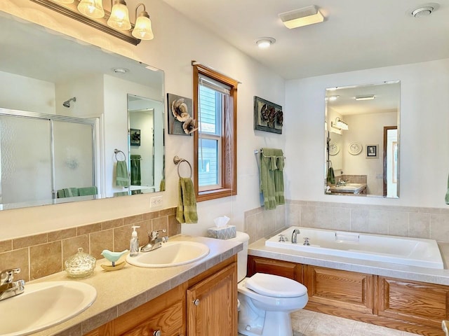 bathroom with tasteful backsplash, tile patterned floors, toilet, a bath, and double sink vanity