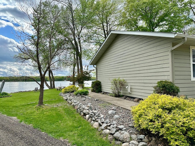 view of side of property with a yard and a water view