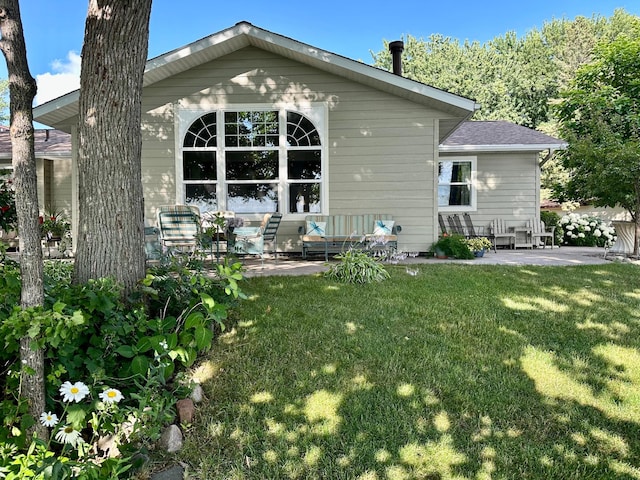 rear view of house featuring a patio, outdoor lounge area, and a yard