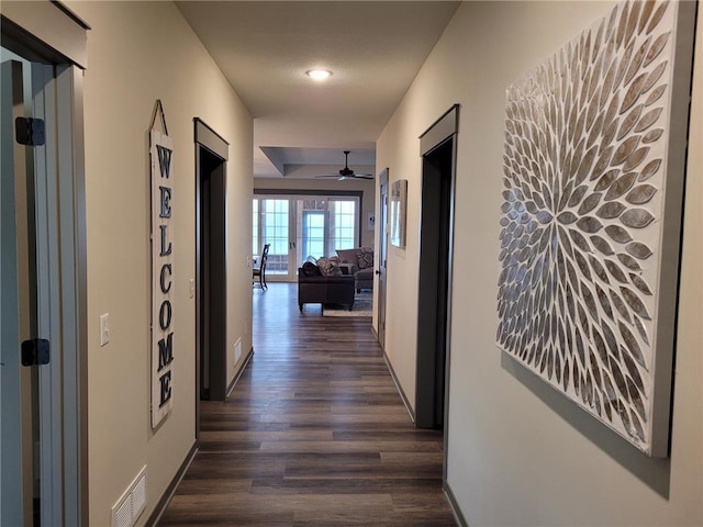 hall featuring a textured ceiling and dark hardwood / wood-style flooring