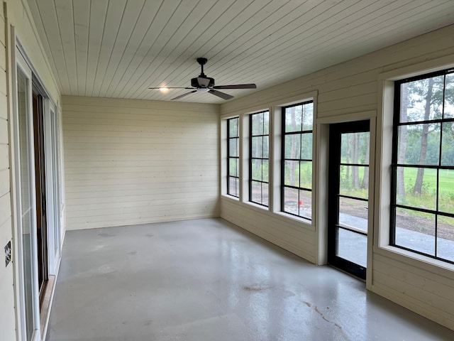 unfurnished sunroom featuring ceiling fan and a healthy amount of sunlight