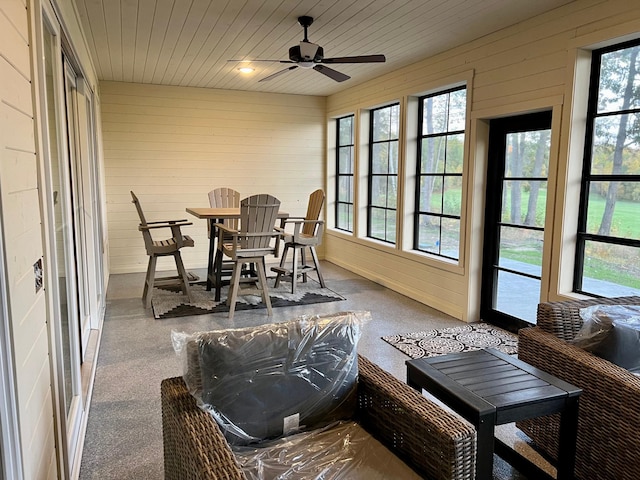 sunroom / solarium featuring ceiling fan, a wealth of natural light, and wooden ceiling