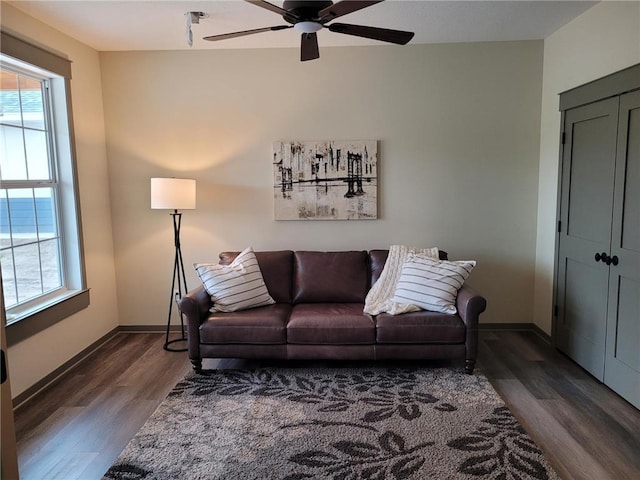 living room featuring dark wood-type flooring, plenty of natural light, and ceiling fan