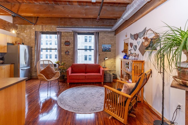 living area with beam ceiling, brick wall, dark wood-type flooring, and wooden ceiling