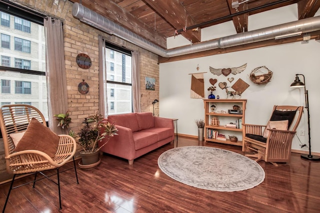 living area featuring dark hardwood / wood-style flooring, wooden ceiling, brick wall, and beam ceiling